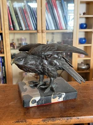 une statue représentant un oiseau perché sur un bloc de marbre