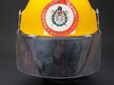 yellow fireman helmet with clear visor on a black base
