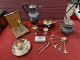de nombreux objets en argent posés sur une table recouverte d'une nappe rouge