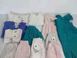 beaucoup de vêtements pour bébés et d'autres vêtements à vendre sur une table
