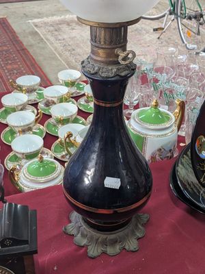 a lamp that is on a table with many cups and saucers