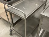 two stainless steel tables with a microwave on top of them