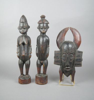 deux statues en bois représentant un homme et une femme debout l'un à côté de l'autre