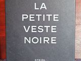 un livre posé sur une table, à côté d'un vase