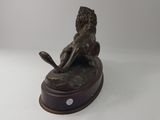 bronze statue of a lion on a wooden base on a white background