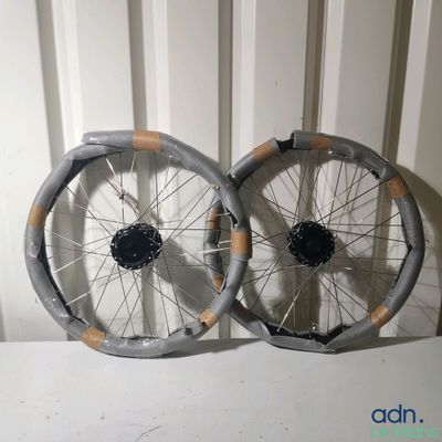 une paire de roues à rayons posées sur une surface blanche