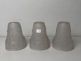three cement vases sitting on a white surface