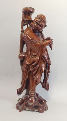 statue en bois représentant une femme tenant un vase et un oiseau