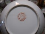 a close up of a white vase with a red stamp on it