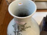 a vase that is sitting on a table next to a statue