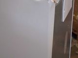 a white refrigerator sitting in the middle of a room
