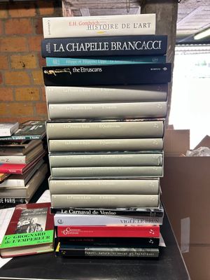 many books stacked on top of each other on a table