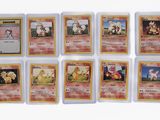 a close up of a collection of pokemon cards on a white surface