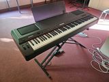a keyboard and a laptop on a stand in a room