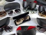 many pairs of sunglasses sitting on a white surface