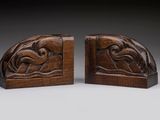 a pair of carved bookends with a bird on a branch