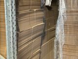 une grande pile de cartons dans un entrepôt où se trouvent de nombreuses palettes