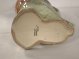 a close up of a vase on a white surface