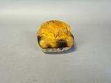 a close up of a yellow glass object on a white surface