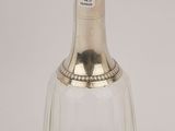 a silver and glass bottle with a stopper on a white background