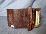 un vieux livre est ouvert sur une surface grise