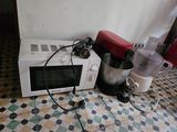 a microwave and a blender sitting on a tiled floor