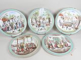 four plates with a painting of a village scene on them