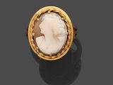 une bague en or 18 carats ornée d'un camée en coquillage sculpté