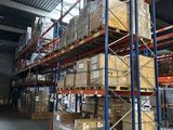un grand entrepôt rempli de boîtes et de palettes