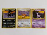 trois cartes pokemon posées les unes sur les autres sur une table