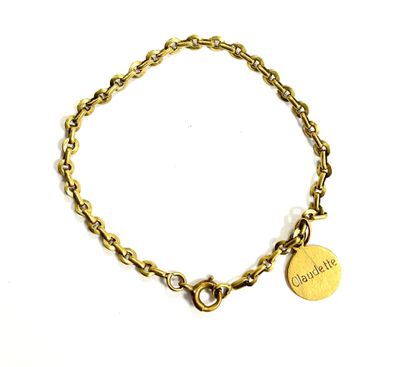 a close up of a gold chain bracelet with a heart charm