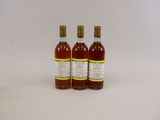 three bottles of wine sitting next to each other on a white surface