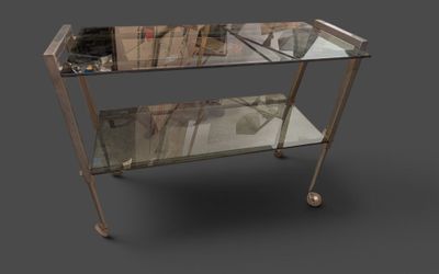 une table en verre surmontée d'un piètement en métal