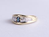 Gros plan sur une bague en or ornée d'un saphir bleu et de diamants