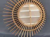 un miroir fixé au mur, fait de tiges de bambou