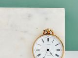 a white marble block with a gold clock on it