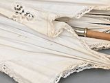 three umbrellas with lace on them on a table
