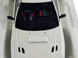 a white toy car in a white box on a white surface