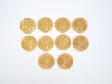 several gold coins arranged in a heart shape on a white surface