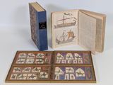 un livre ouvert posé sur une table blanche, à côté d'un livre bleu