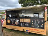 a food truck that is parked in the grass