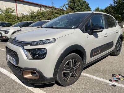 La Citroën blanche est garée sur un parking, à côté d'autres voitures