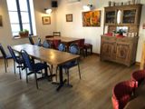 tables and chairs in a room with a wooden table and chairs