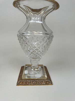 un vase en verre avec un bord doré sur une base carrée
