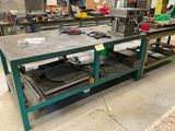 un établi au milieu d'une usine, sur lequel sont posés de nombreux outils