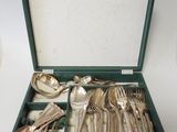 silverware in a green case on a white table