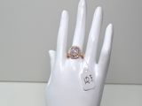 une main blanche à laquelle est fixée une bague et une étiquette