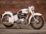 a white motorcycle that is parked in front of a brick wall