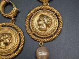 two pairs of gold earrings with pearls on a black surface