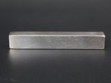 a block of metal on a black surface